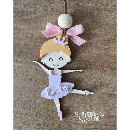 Decorative ballerina ornament with a pink bow on a wooden surface, branded 'Splinter Spark'.