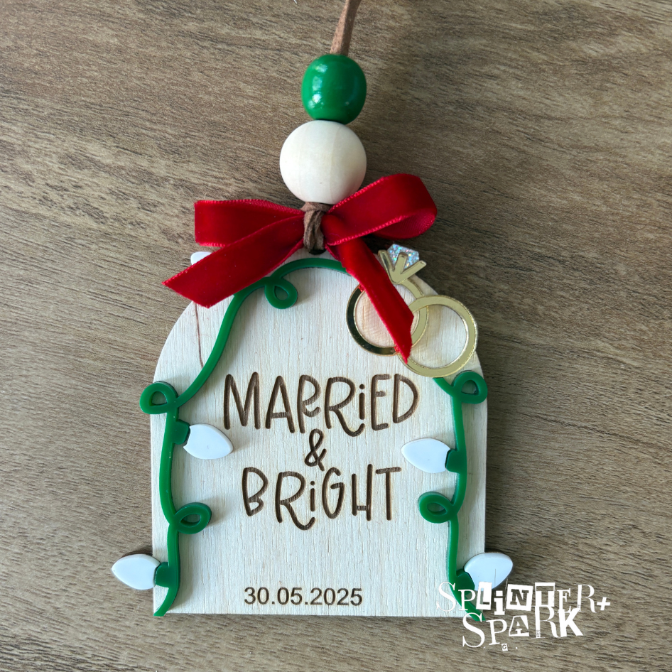 Decorative ornament with 'Married & Bright' text and a bow on a wooden surface.